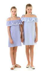 Wall Mural - Sisters in Identical Light Dresses Standing and Holding Hands