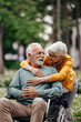 © bnenin - Senior woman, embracing her disabled husband lovingly.
