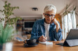 © bnenin - Senior woman, attending a business meeting.