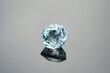 Natural blue aquamarine loose gemstone. Unheated, untreated, loupe clean, VS, oval cut, shaped, good polish surface, shiny, full of sparkle blue gemstone on light greay radial gradient background.
