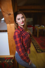 Wall Mural - Vertical shot of a Caucasian female with a red checkered shirt at home