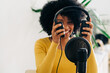 © ADDICTIVE STOCK - Positive young African American woman talking at online radio station