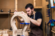 © ADDICTIVE STOCK - Luthier building guitar at table in workshop