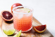 Blood orange margarita cocktail on white table background. Summer cocktails, refreshing drinks, cocktail party concept. Copy space