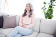 © deagreez - Photo of attractive nice happy positive old woman sit sofa good mood weekend indoors inside house home