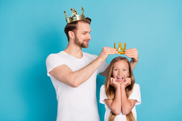 Poster - Photo of handsome guy put crown on head amazed cheerful girl hands on cheeks isolated on blue color background