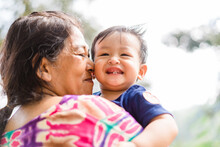 Happy Loving Family.Indian Grandmother And Grandson Are Having A Good Time Together And Playing Peekaboo And Kiss Her Grandson Outdoor.mixrace Boy Smiling Laughing With His Mother.Kid Boy Child.