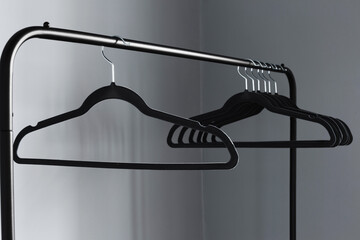 Wall Mural - empty black clothes hanger on gray wall background