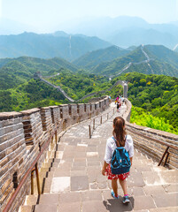 China travel adventure woman tourist backpacker walking backpacking on the Great Wall at famous Badaling destination in Beijing. Asia summer vacation tourism lifestyle. View of mountain landscape.