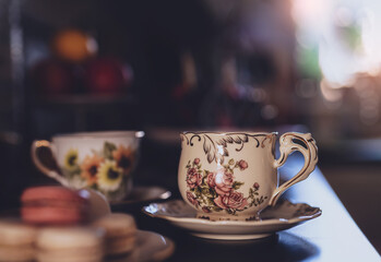 Hot cup of tea with blurry kitchen background. Cup of aroma dring with steam, Cozy sense of Afternoon tea in realaxing day at home in retro tone.Traditional English tea time