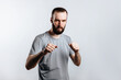 © Daria Lukoiko - Portrait of handsome young man frowning while looking at camera holding fists and boxing on white background with space for advertisement mock up