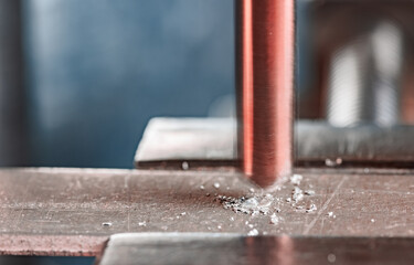 Wall Mural - Drilling process with shavings close-up at the workplace in workshop