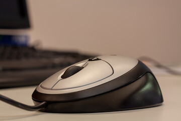 Canvas Print - Closeup shot of a grey-black computer mouse on the office table