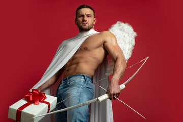 Valentines Day man angel. Sexy guy with angels wings. Cupid. Amour. February 14. Arrow of love. Isolated on red.