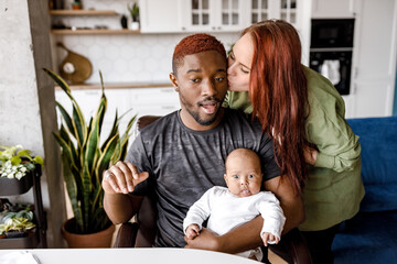 Happy african American American young father sit with small boy son child, make selfie with caucasian wife, smiling mixed race family with child rest at home with gadgets, smile enjoy weekend together