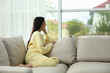 © New Africa - Young woman relaxing on sofa at home, space for text