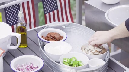 Wall Mural - Preparing individual grilled pizzas on an outdoor gas grill.