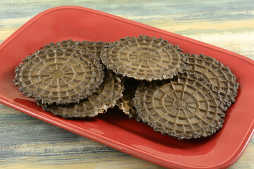 Wall Mural - Chocolate waffle biscuit or cookie snacks on red serving plate on table