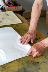 Wall Mural - a calligrapher is folding rice paper and writing calligraphy preparations
