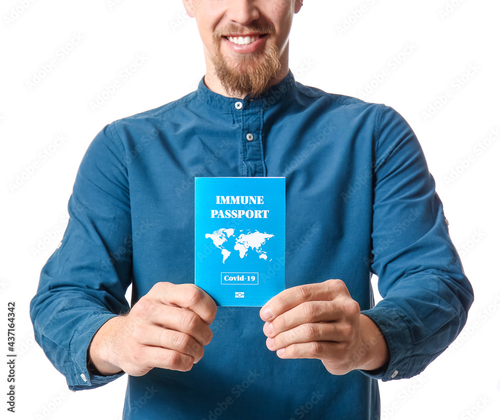 Young man with immune passport on white background
