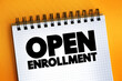 Open Enrollment text quote on notepad, concept background