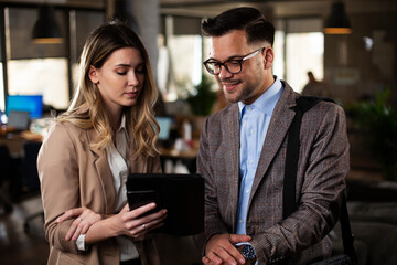 Wall Mural - Colleagues talking in the office. Businesswoman and businessman discussing work in office.