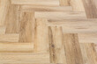 © uladzimirzuyeu - Laminate and parquet with herringbone background. Wooden floor with a chevron pattern in the living room of the designer interior