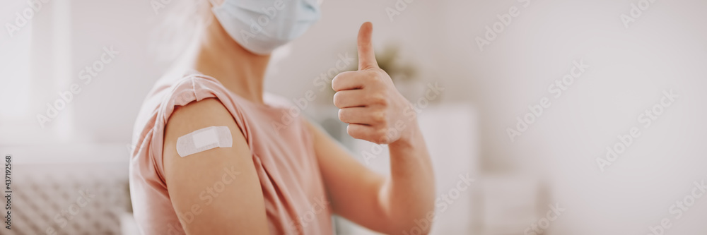 Woman showing thumb up after inoculation against Covid 19. - obrazy, fototapety, plakaty 