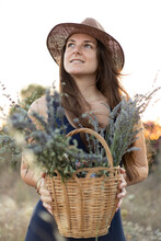 Portrait Of A Young Woman Holding A Basket Of Wild Flowers, Looking Up. Soft Focus