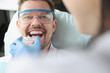 © H_Ko - Doctor tries on plastic mouthguard for young smiling man to correct bite