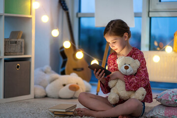 Poster - Pretty little girl with smartphone in night room