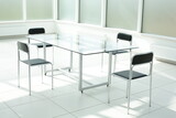 Fototapeta  - Glass table and chairs in a bright office space