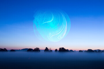 Wall Mural - a glowing ball of energy floating above a misty field just before sunrise on a summers morning