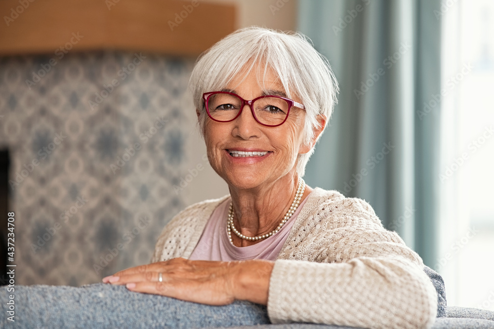 Happy senior woman wearing red spectacles at home - obrazy, fototapety, plakaty 
