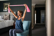 © Rido - Mature woman using resistance band while training triceps at home