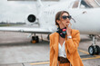 Cloudy weather. Passenger woman that is in yellow clothes, sunglasses and with luggage