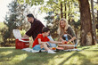 © gstockstudio - Happy young mother and father with little boy smiling while having picnic outdoors