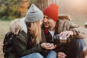 Wall Mural - Travel couple camping with map in the forest. Concept of trekking, adventure and seasonal vacation.