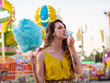 Attractive Caucasian female posing with blue cotton candy at a carnival