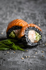 Closeup of two maki sushi rolls with black rice and sesame 