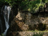 Fototapeta Dmuchawce - naturalny wodospad na skale wśród zieleni - poziomo