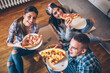 © BalanceFormCreative - Group of students  eating pizza at the home .They sitting on floor and relaxing.
