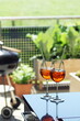 two summer apperitive drinks on a table on a balcony garden