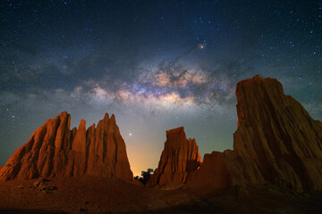 Wall Mural - Beautiful milky way raised over natural earth pillar in various shapes crafted by soil erosion in Lalu, Sakaeo, Thailand