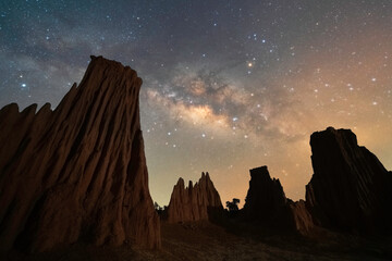 Wall Mural - Beautiful milky way raised over natural earth pillar in various shapes crafted by soil erosion in Lalu, Sakaeo, Thailand
