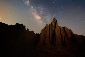 Wall Mural - Beautiful milky way raised over natural earth pillar in various shapes crafted by soil erosion in Lalu, Sakaeo, Thailand