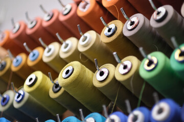 group of sewing threads in skeins. A bunch of large multicolored spools of thread. Atelier workshop. A set of colored threads for sewing on reels.