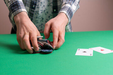 hands take the casino poker chips on the green table, gambling and luck concept