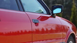 Fototapeta Sawanna - Czerwony samochód prosto po wyjechaniu z myjni