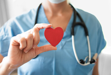 Nurse medical worker holding up red heart. Healthcare and medical health concept. 